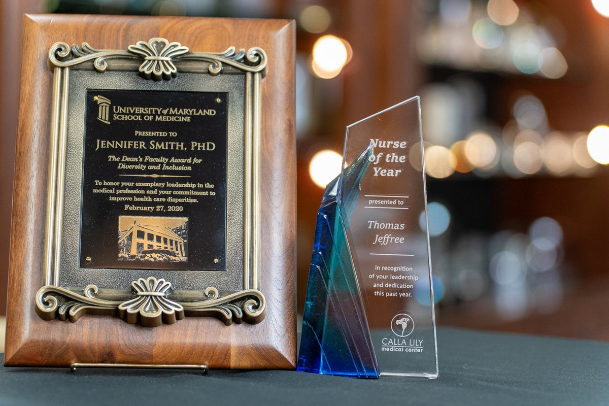 Traditional recognition plaque beside a personalized freestanding award